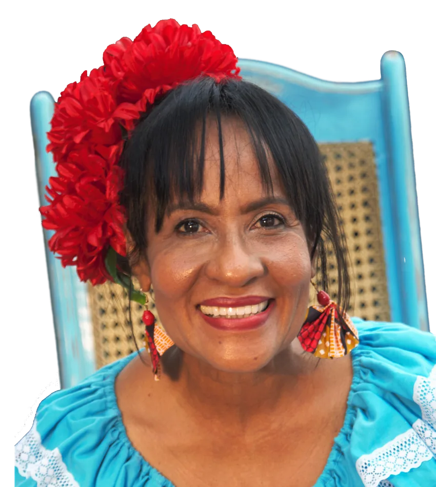 Martina Camargo smiling in turquoise with red flowers in her hair